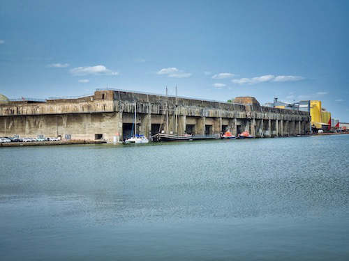 Auf der andren Seite des Hafenbeckens ein weiterer, kleinerer Bunker der heute ein U-Boot-Museum beherbergt, hier kann man sich ein altes französischen U-Boot von Innen anschauen. Ich verzichtete, stieg mit Berate auf das Dach des Bunkers und genoss den Rundblick. Eine riesige, hohe Brücke spannt sich über die breiten Loiremündung, ein imposanter Anblick. Davor ein neues Kreuzfahrtschiff, die Celebrity Ascent, noch nicht ganz fertig, aber ab Dezember soll es in der Karibik auf große Fahrt gehen.